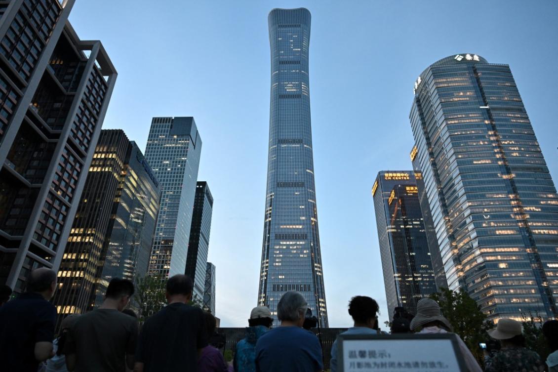 People gather near the CITIC Tower in Beijing on June 26, 2026, after an eyewitness reported plane debris at the base of Beijing’s tallest building. (AFP file photo)