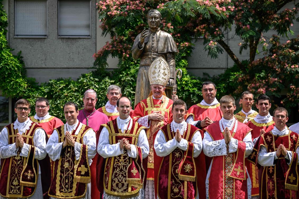 Swiss traditionalist Catholic Bishop Bernard Fellay, priests and deacons pose next to a statue of Saint Pius X after an ordination ceremony of the traditionalist Catholic Society of Saint Pius X, in Econe, western Switzerland, on June 29, 2026. (AFP)