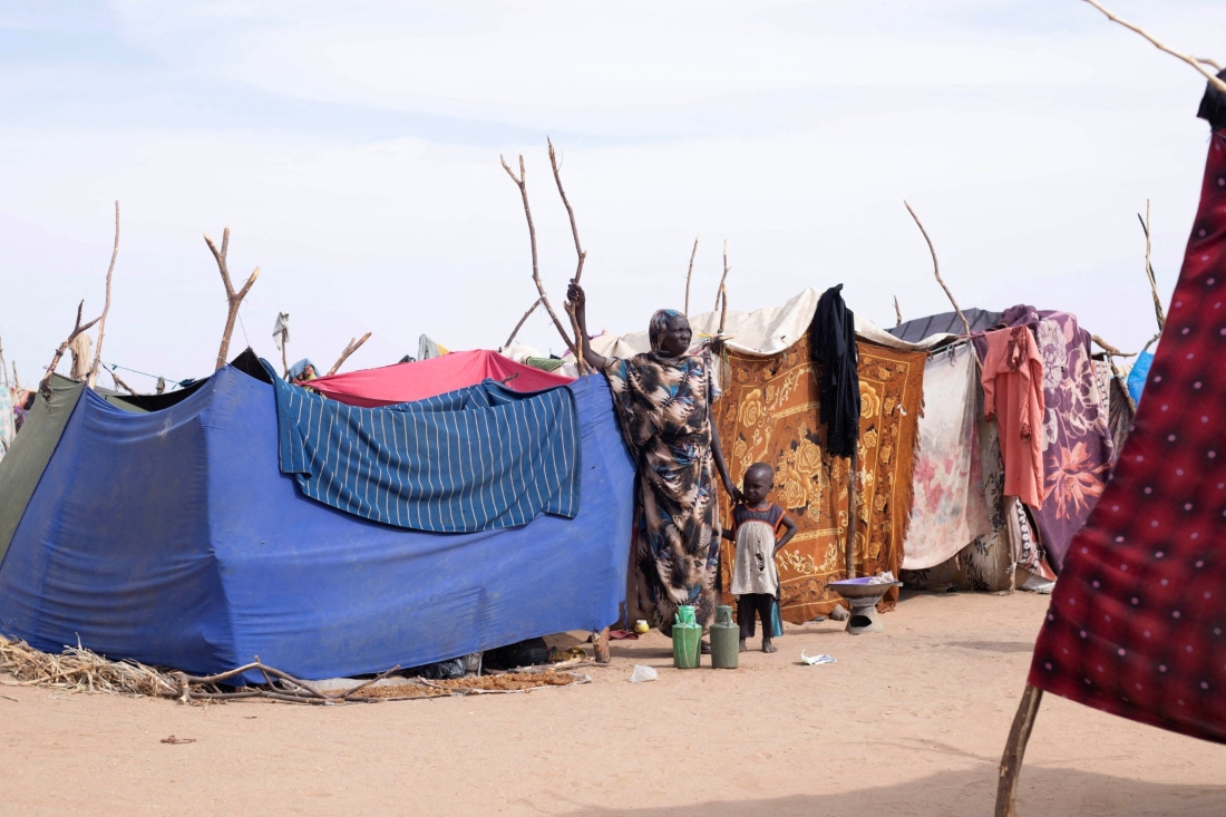 A displaced Sudanese woman and child stand near a make shift shelter in the southwestern edge of Tawila, in war-torn Sudan's western Darfur region. (AFP)