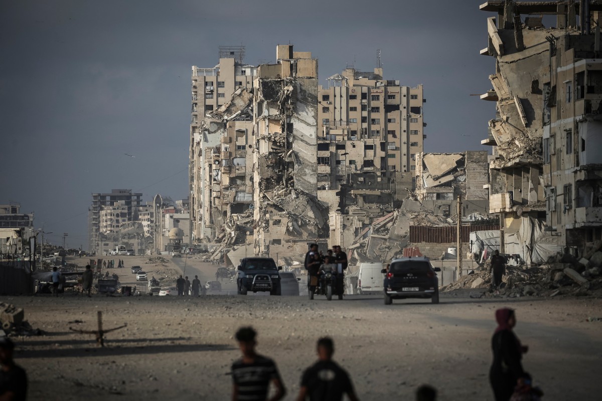 Palestinians walk along a road in Gaza City, July 3, 2026. (AFP)