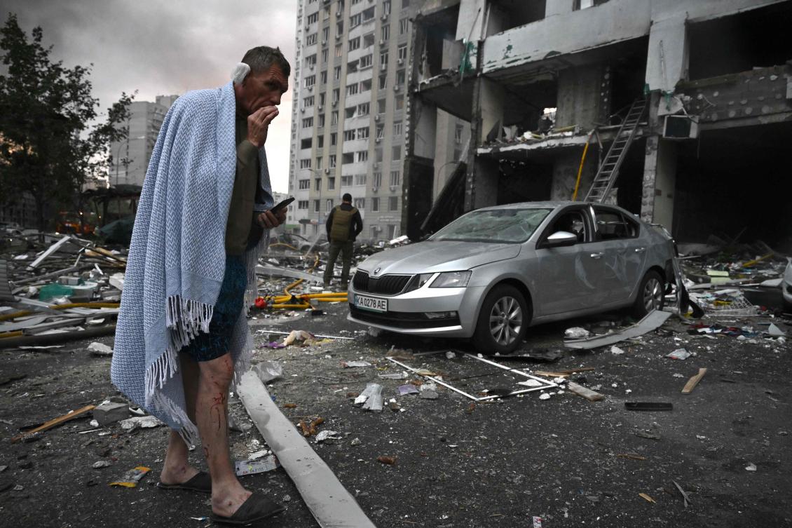 A local resident smokes as he reacts outside a multistory residential building damaged following a Russian missile strike on the Ukrainian capital of Kyiv, July 6, 2026. (AFP)