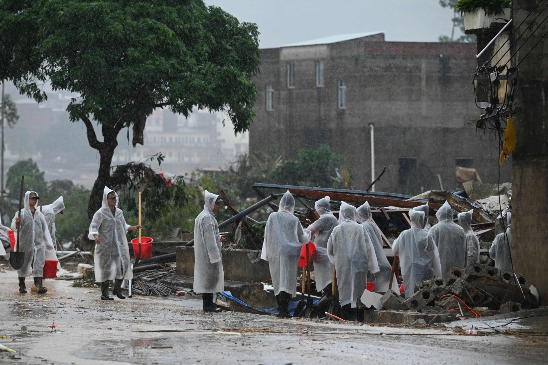 Security personnel gather during cleanup operations in Liulan village, which was flooded when the Liulan reservoir collapsed on July 6, in Hengzhou city, China. (AFP)