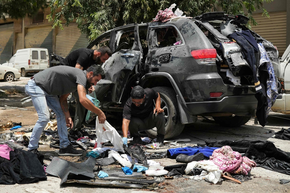 First responders inspect the wreckage of a car reportedly targeted by an Israeli strike in Nabatieh, Lebanon. (AFP)