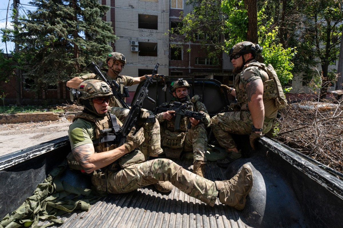 Soldiers of the Alcatraz Battalion ride aboard a military vehicle as they head to their position at the frontline town of Druzhkivka, in the Donetsk region. (AFP)