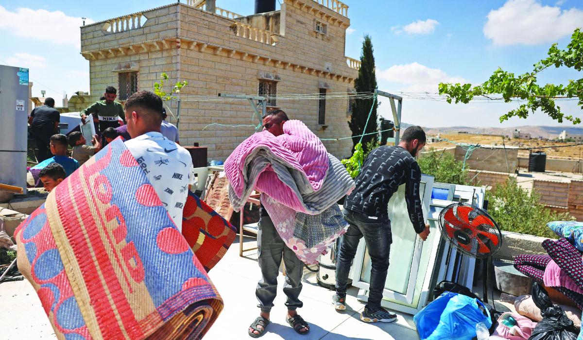 Palestinians carry their belongings after Israeli forces demolished their home in the village of Al-Rifayia, south of Hebron in the occupied West Bank on Thursday. (AFP)