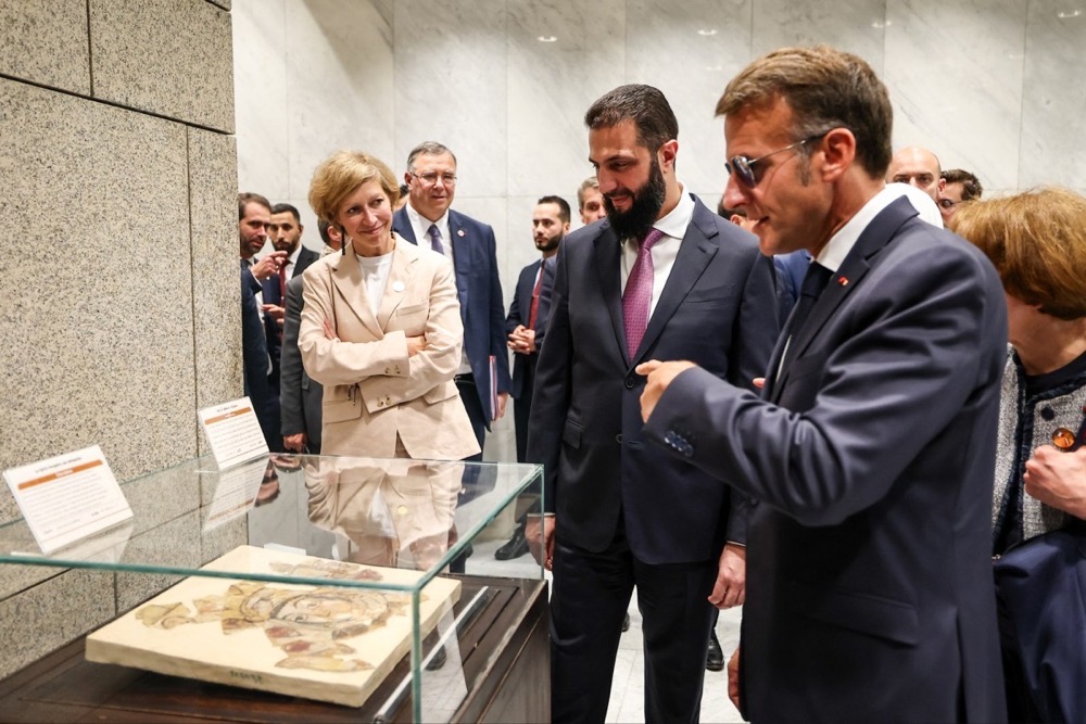 Interim President Ahmad Al-Sharaa and President Emmanuel Macron inspect repatriated artefacts at the People’s Palace in Damascus on July 7. (AFP)