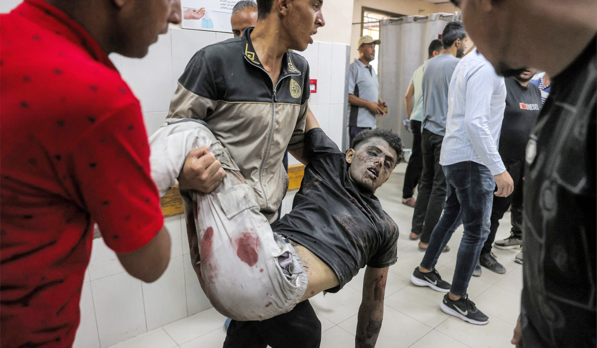 A man who was injured following a reported Israeli strike on a tent according to medics, is carried by another to the trauma ward for treatment at Nasser Medical Complex in Khan Yunis in the southern Gaza Strip on July 8, 2026. (AFP)