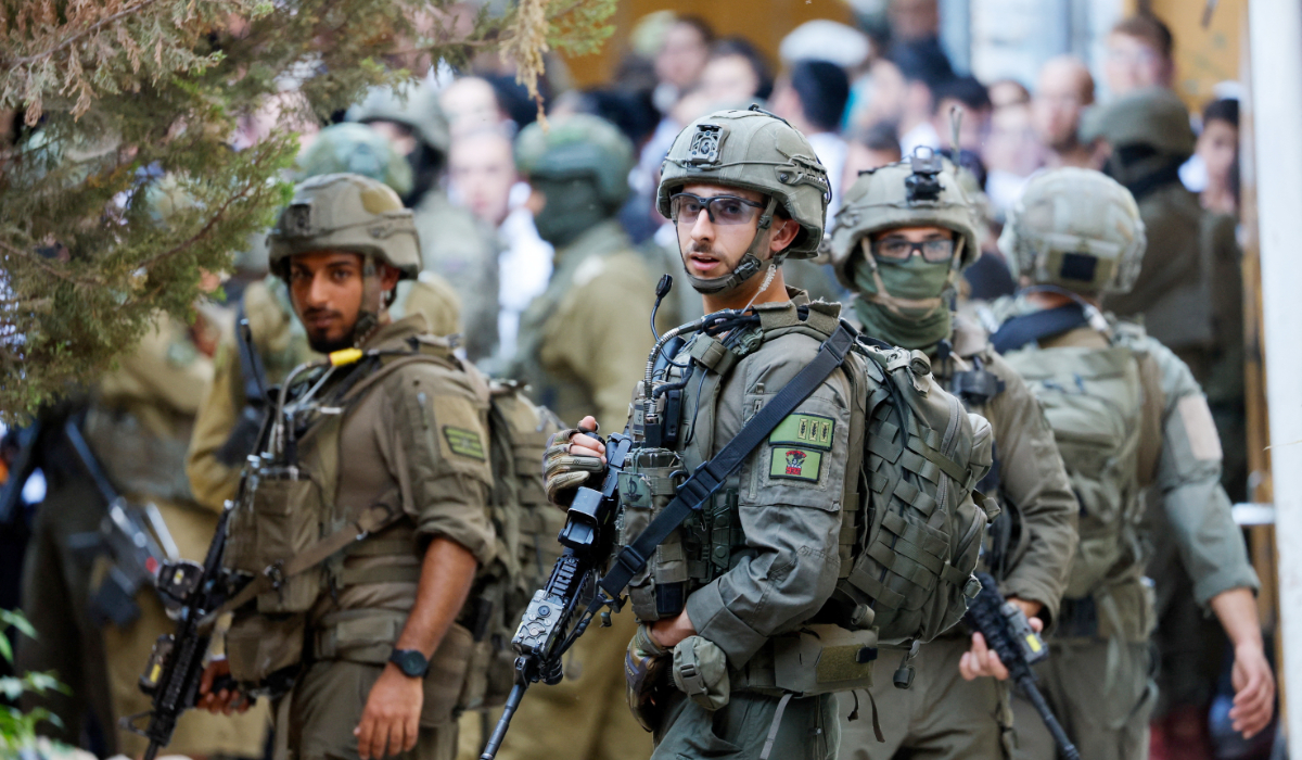 Israeli soldiers keep watch as Israeli settlers take part in a weekly tour in Hebron, in the Israeli-occupied West Bank, July 11, 2026. (REUTERS)