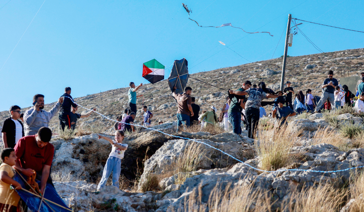 Palestinians and solidartiy activists fly kites towards the Israeli settelment of Har Bracha from the village of Burin, south of Nablus in the occupied West Bank on July 10, 2026. (AFP)