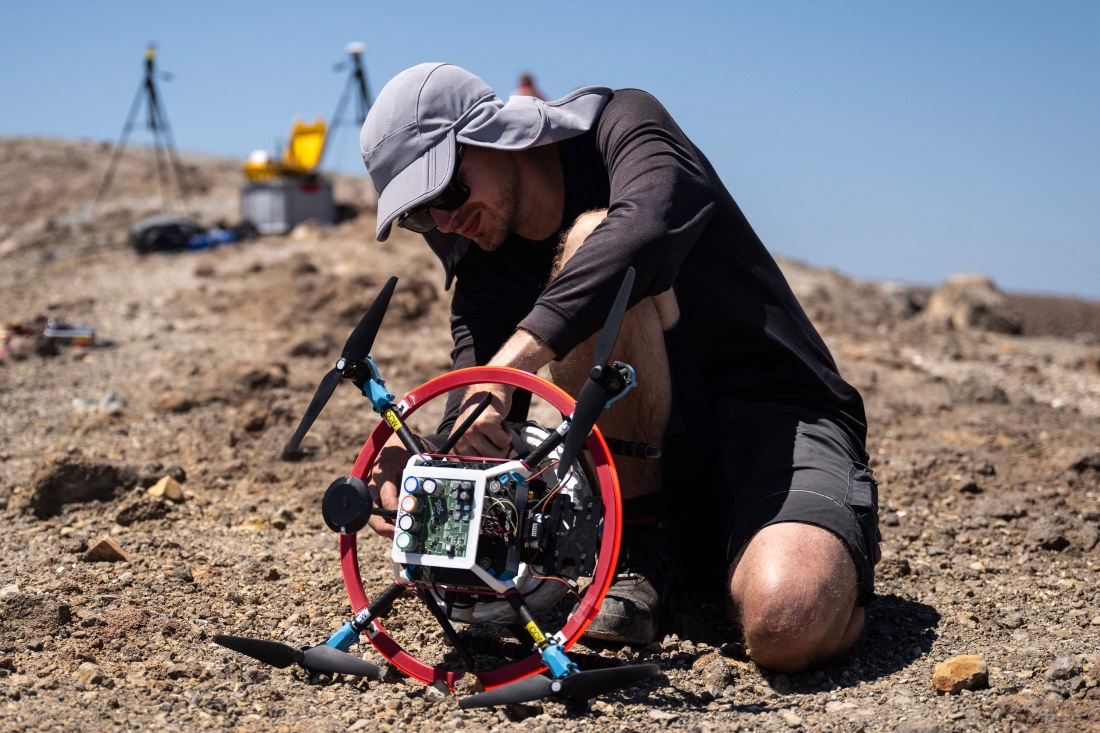 A vulcanologist from the University of Munich prepares a drone with a mirror used to reflect a laser and collect data from gas emissions in the crater of La Fossa, Italy. (AFP)