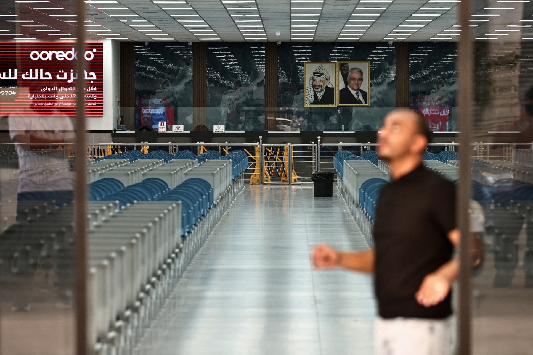 A Palestinian government employee walks past the empty passenger hall on the Palestinian side of the King Hussein (Allenby) bridge, the main border crossing between the Israel-occupied West Bank and Jordan, Sept. 24, 2025. (AFP)