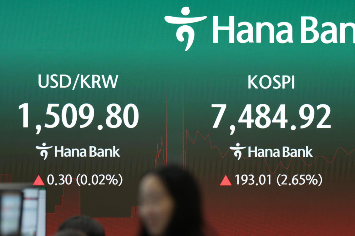 A dealer walks past near the screens showing the Korea Composite Stock Price Index (KOSPI) and the foreign exchange rate between US dollar and South Korean won at a dealing room of Hana Bank in Seoul, South Korea, on July 10, 2026. (AP Photo/Lee Jin-man)