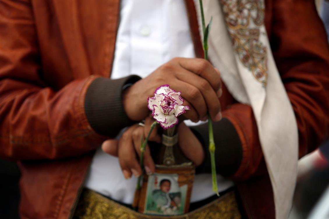 FILE - A member of the Baha'i faith holds a flower as he protests outside a state security court during a hearing in the case of a fellow Baha'i man charged with seeking to establish a base for the community in Yemen, in Sanaa, Yemen, Sunday, April 3, 2016. (AP Photo/Hani Mohammed, File)