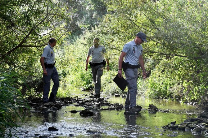 Members of the French Office for Biodiversity check the level of the Yser river amid an intense drought in the country in Herzeele, northern France in 2022. (AFP/File)