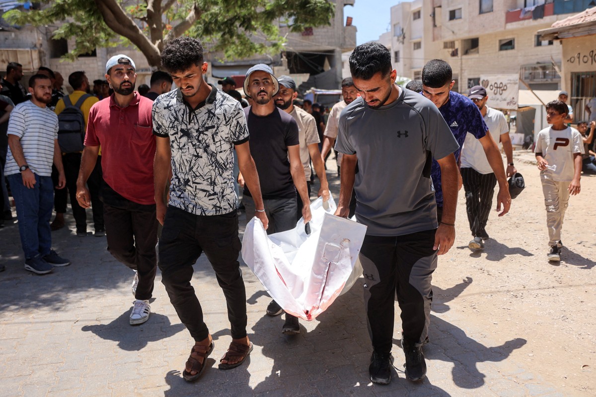 Men carry the body of one of several victims who were killed after a police station was was hit by Israeli bombardment in the Jabalia camp. (AFP)