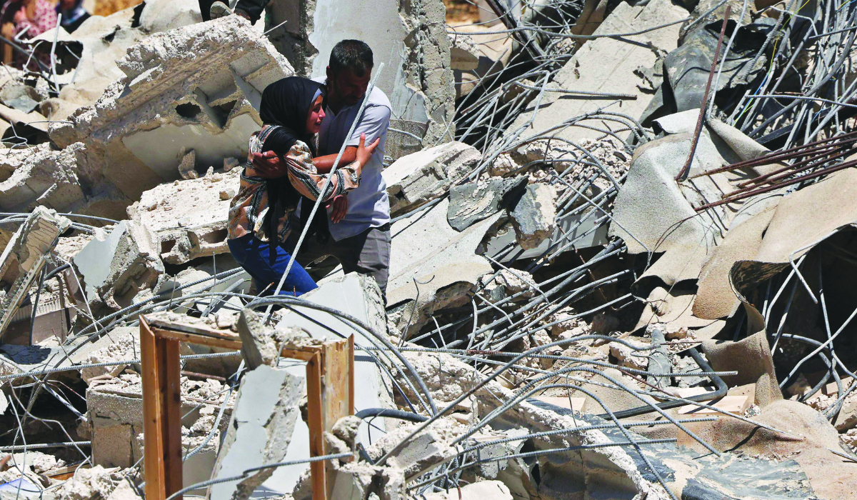 Local residents walk through the rubble of a Palestinian house that was demolished by Israeli security forces' as it was reportedly built without a permit in the village of al-Dirat, south of Hebron in the occupied West Bank, on July 14, 2026. (AFP)