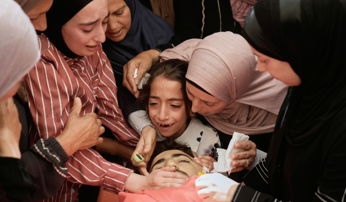 Mourners take a last look at the body of Palestinian Fadi Na'asan, 17, who succumbed to his wounds sustained during clashes with Israeli army soldiers last Saturday, during his funeral in the West Bank village of al-Mughayyir, Saturday, July 18, 2026. (AP)