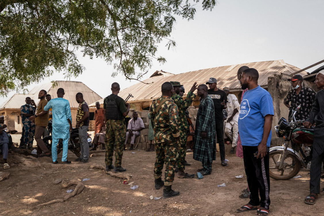 This photo taken on February 5, 2026, shows Nigeria government troops interacting with residents following an attack in Woro, Kwara State. (AFP/File photo)