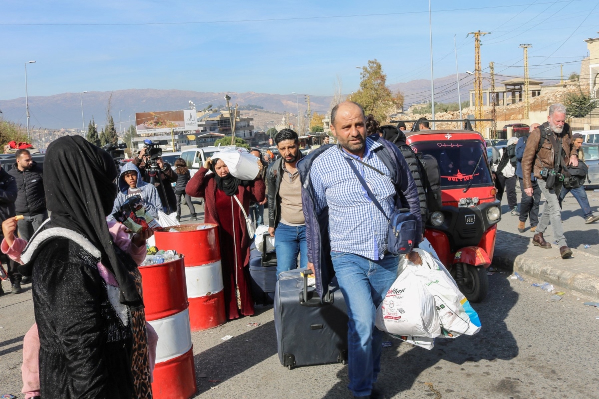Syrian and Lebanese travelers walk at the Al-Masnaa eastern Lebanese border crossing with Syria. (AFP)
