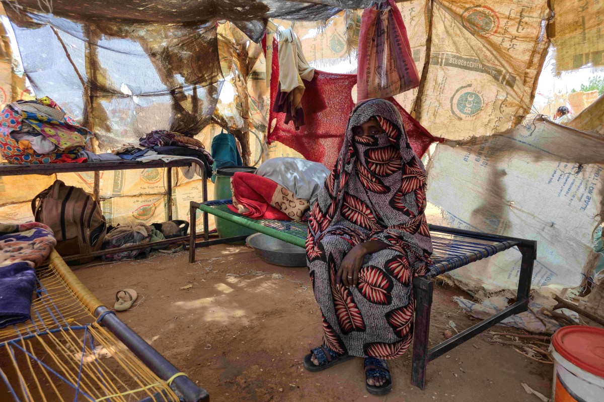 A Sudanese woman sits inside a shelter in the al-Rahmaniya camp for displaced people near the city of El-Obeid in the southern Kordofan region. (AFP)