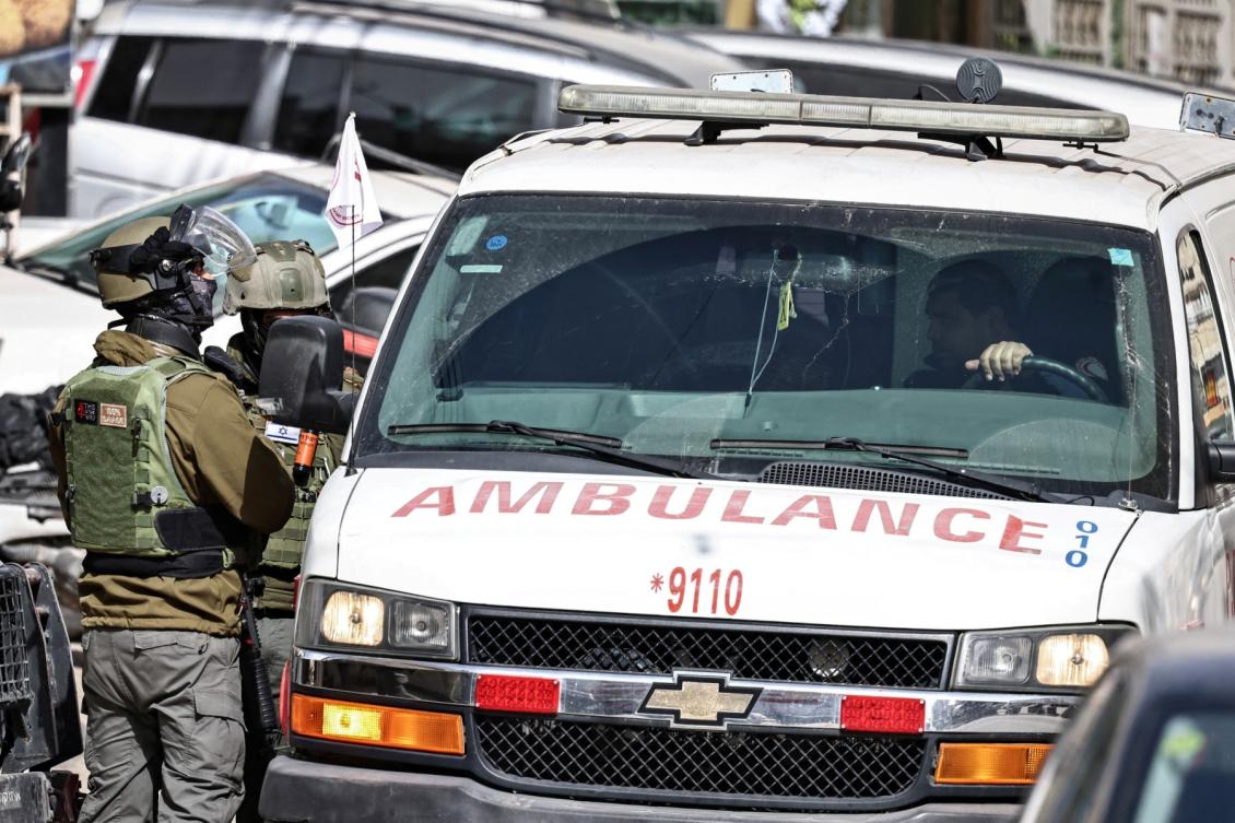 Palestinian ambulance drives past Israeli security forces during the second day of a military operation, in Kafr Aqab some 16 kilometres south of the city of Ramallah, in the Israeli-occupied West Bank. (File/AFP)