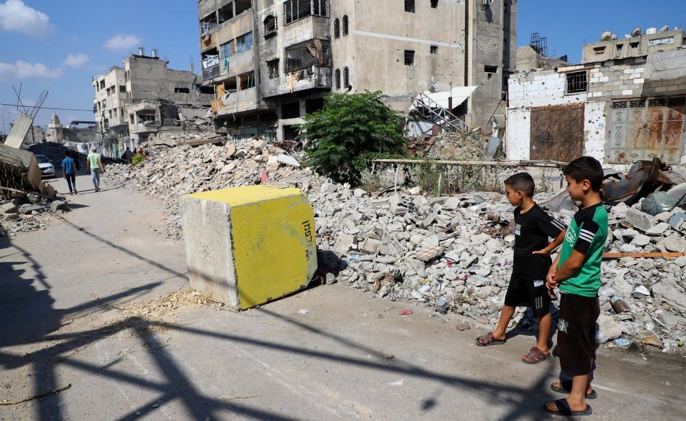 Palestinian boys look at a yellow concrete block marking the ‘yellow zone’ under Israeli military control, Tufah, Gaza City, July 27, 2026. (Reuters)