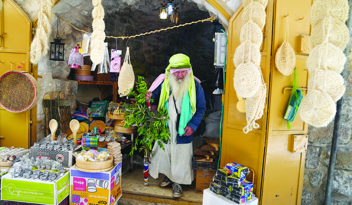 A Palestinian vendor waits for customers inside his shop in Hebron on Monday amid increasing incursions by violent settlers in the Israeli-occupied West Bank. (AP)
