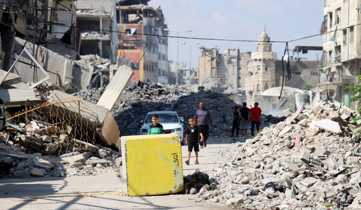 Palestinians look towards a yellow concrete block marking the "yellow zone" under Israeli military control, in Tufah neighborhood, in Gaza City, July 27, 2026. (REUTERS)
