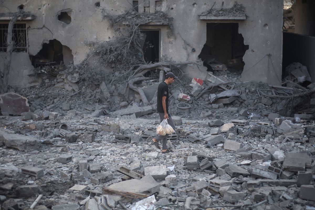A Palestinian man walks through the rubble of destroyed buildings after they were targeted by Israeli strikes the previous night in Deir Al-Balah, central Gaza on Wednesday. (AFP)