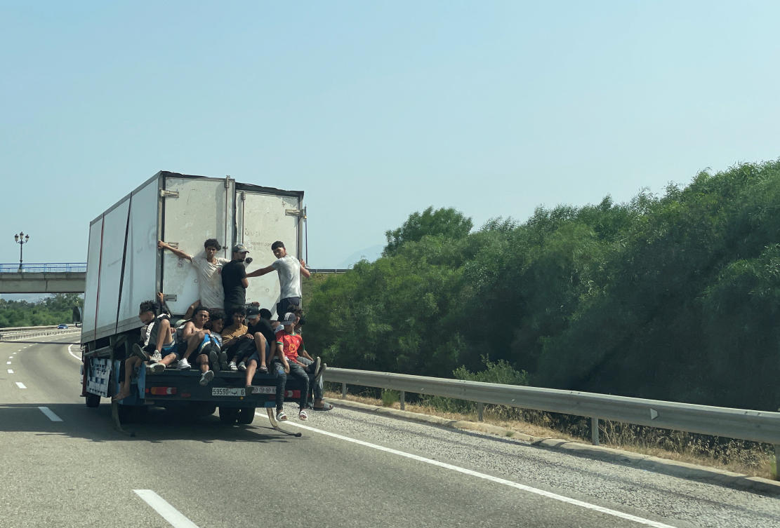 Migrants travel on a truck, while waiting for a chance to cross to the Spanish enclave of Ceuta, on the Moroccan side of the border. (Reuters)
