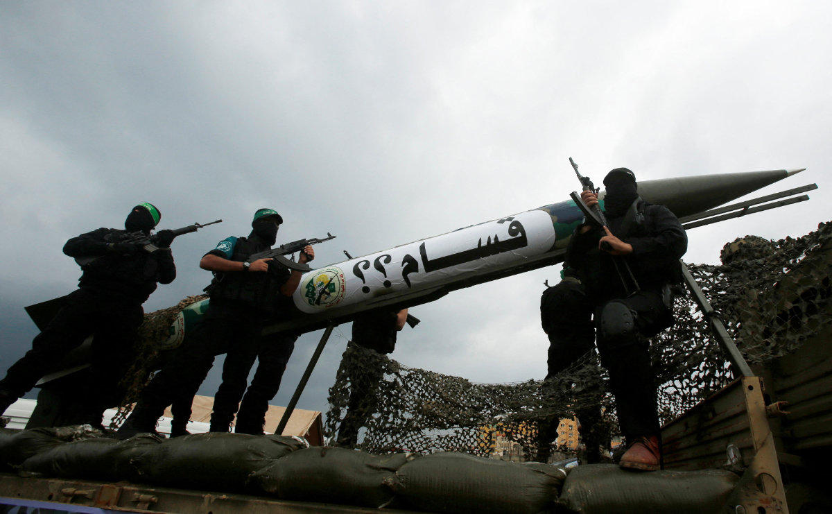 This photo taken on December 14, 2014, shows members of al-Qassam Brigades, the armed wing of the Hamas movement, displaying a home-made rocket during an anniversary celebration. (Reuters/File Photo)