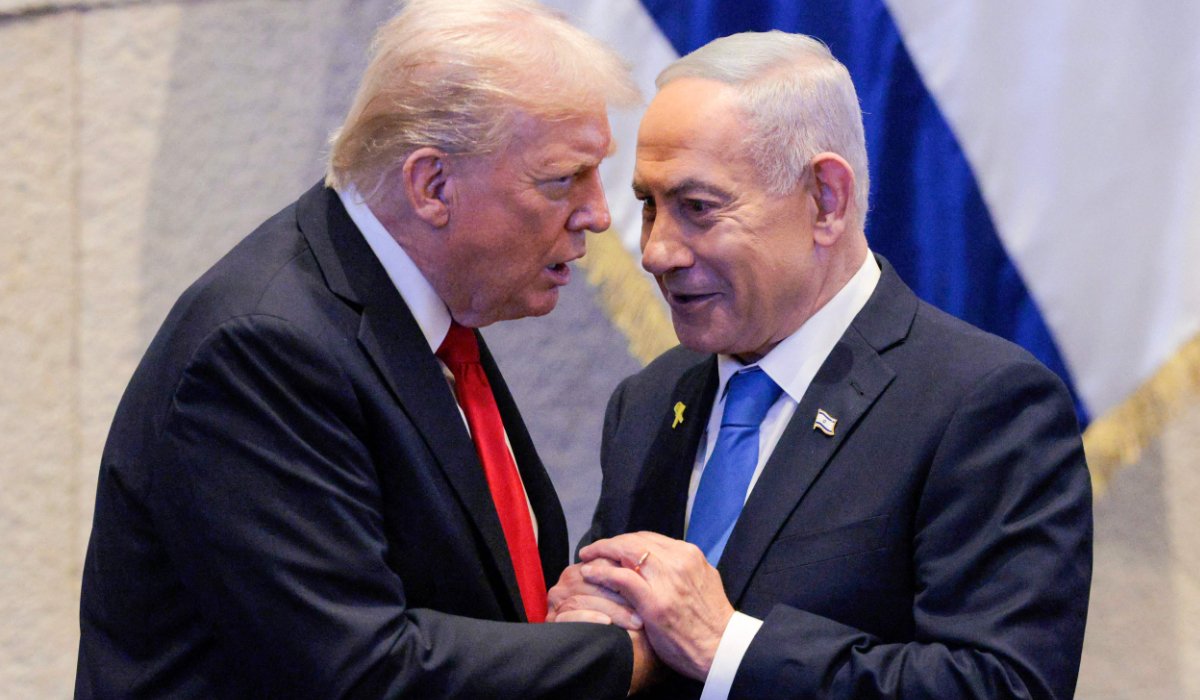 US President Donald Trump (L) holds hands and speaks with Israeli PM Benjamin Netanyahu in Jerusalem on October 13, 2025. (AFP)