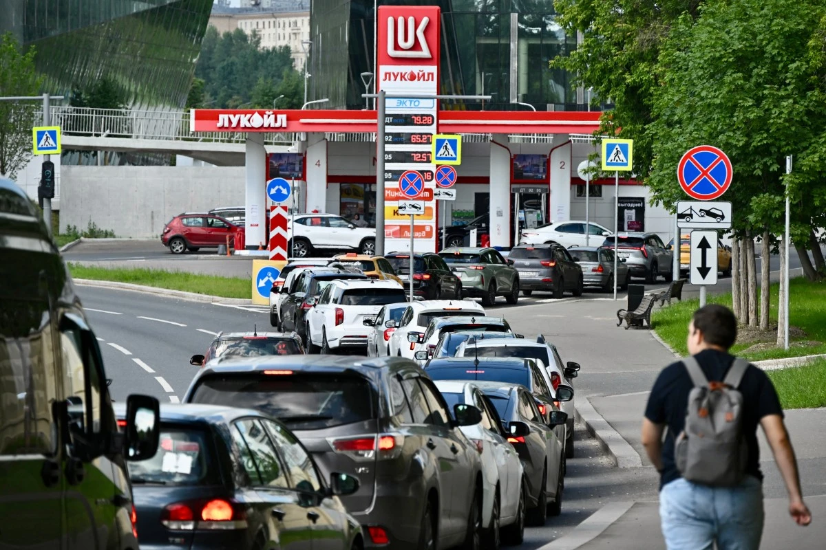 People queue to refuel their cars at a Lukoil petrol station in Moscow, Russia. (AFP)