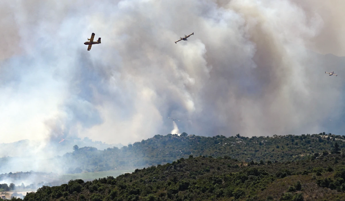 Canadair CL-415 aircrafts of France's Civil Security services drop warter and fly over smoke rising from a wildfire near the Col des Auzines, near Trevillach, southern France, on July 5, 2026. (AFP)