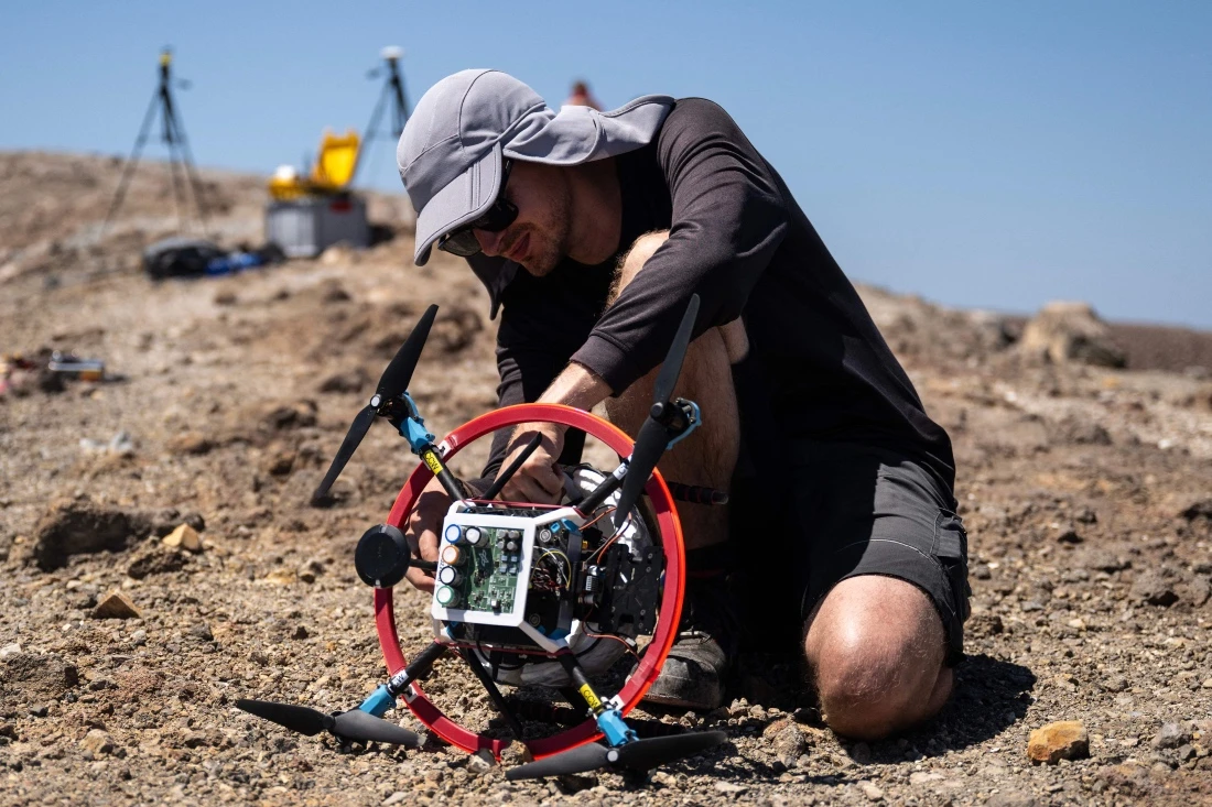 A vulcanologist from the University of Munich prepares a drone with a mirror used to reflect a laser and collect data from gas emissions in the crater of La Fossa, Italy. (AFP)