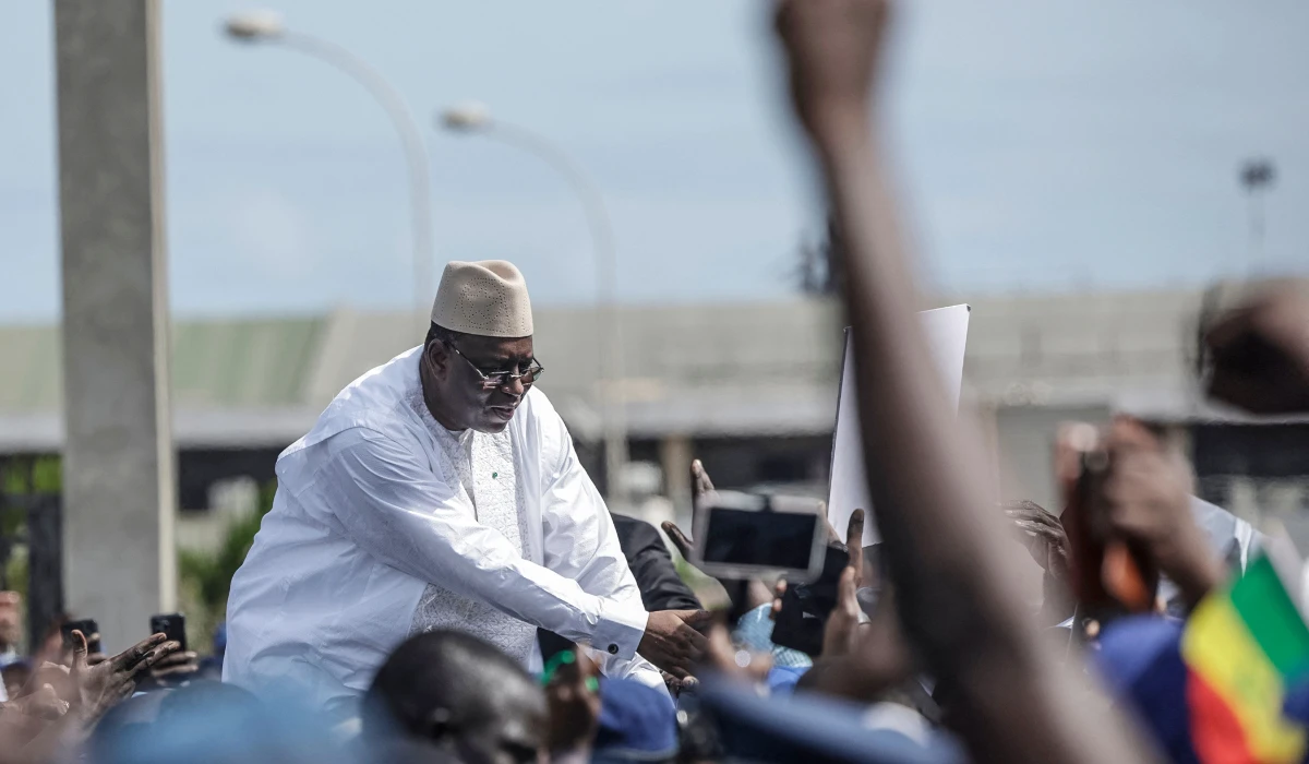 Supporters of former Senegalese President Macky Sall react as he acknowledges the crowd outside the Leopold Senghor Military airport upon his arrival in Dakar on July 17, 2026. (AFP)