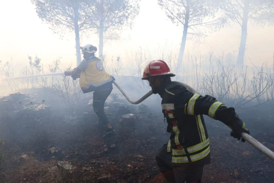 Syrian Civil Defense work to extinguish wildfire in Latakia countryside. (SANA)