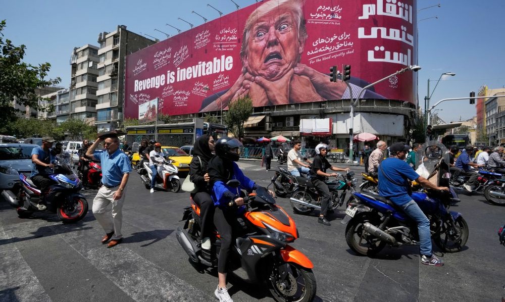 Motorcyclists pass a billboard depicting Donald Trump in Tehran, Iran, Monday, Aug. 24, 2026. (AP Photo)