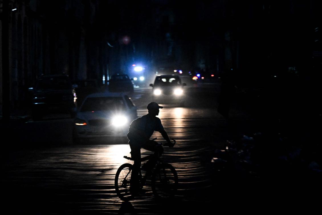 A man rides his bicycle down a street during a blackout in Havana on August 1, 2026. (AFP photo)