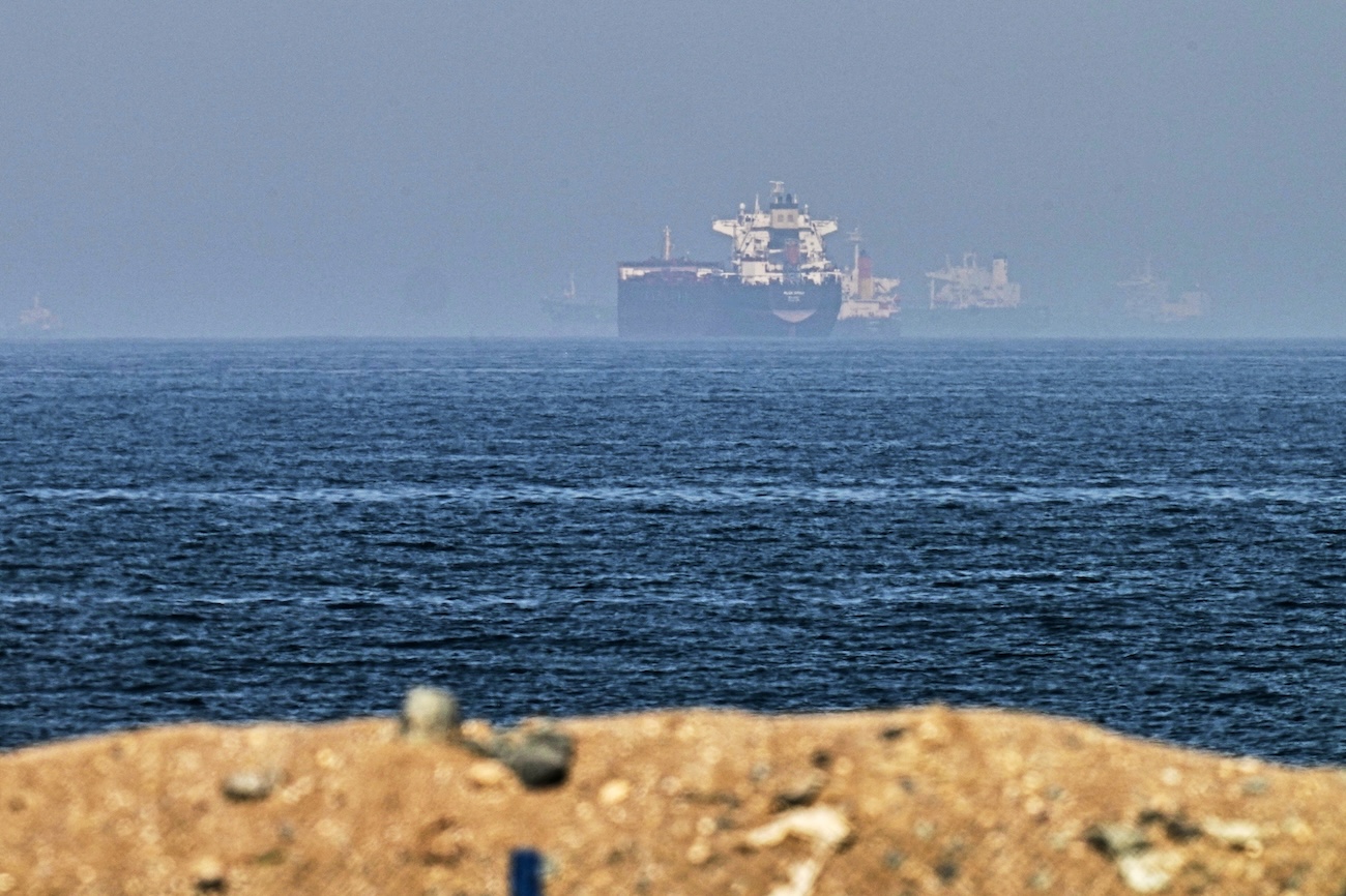 Cargo ships are seen at sea near the Strait of Hormuz, as viewed from a rocky shoreline near Khor Fakkan, UAE. (File/AP)