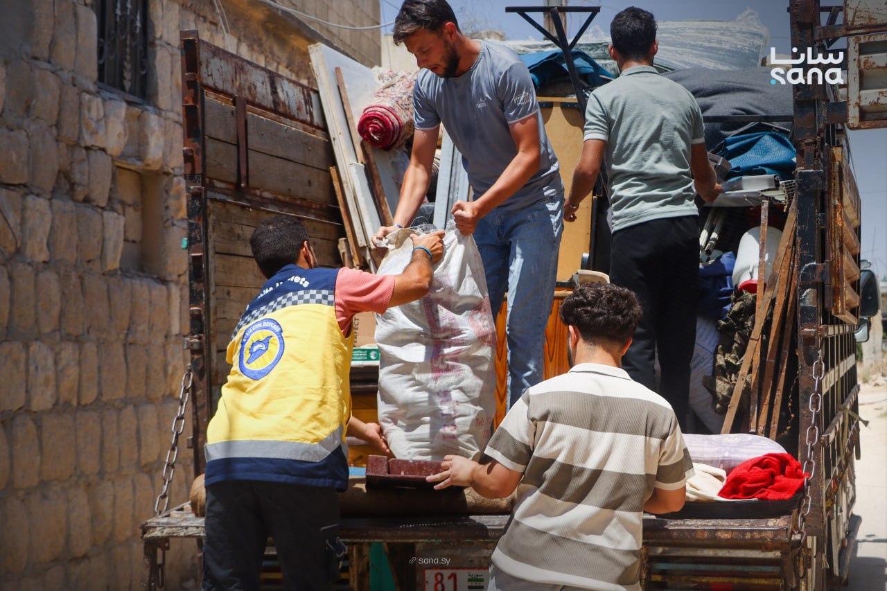 Syrian families ride in a voluntary return convoy leaving displacement camps in northern Syria. (SANA)