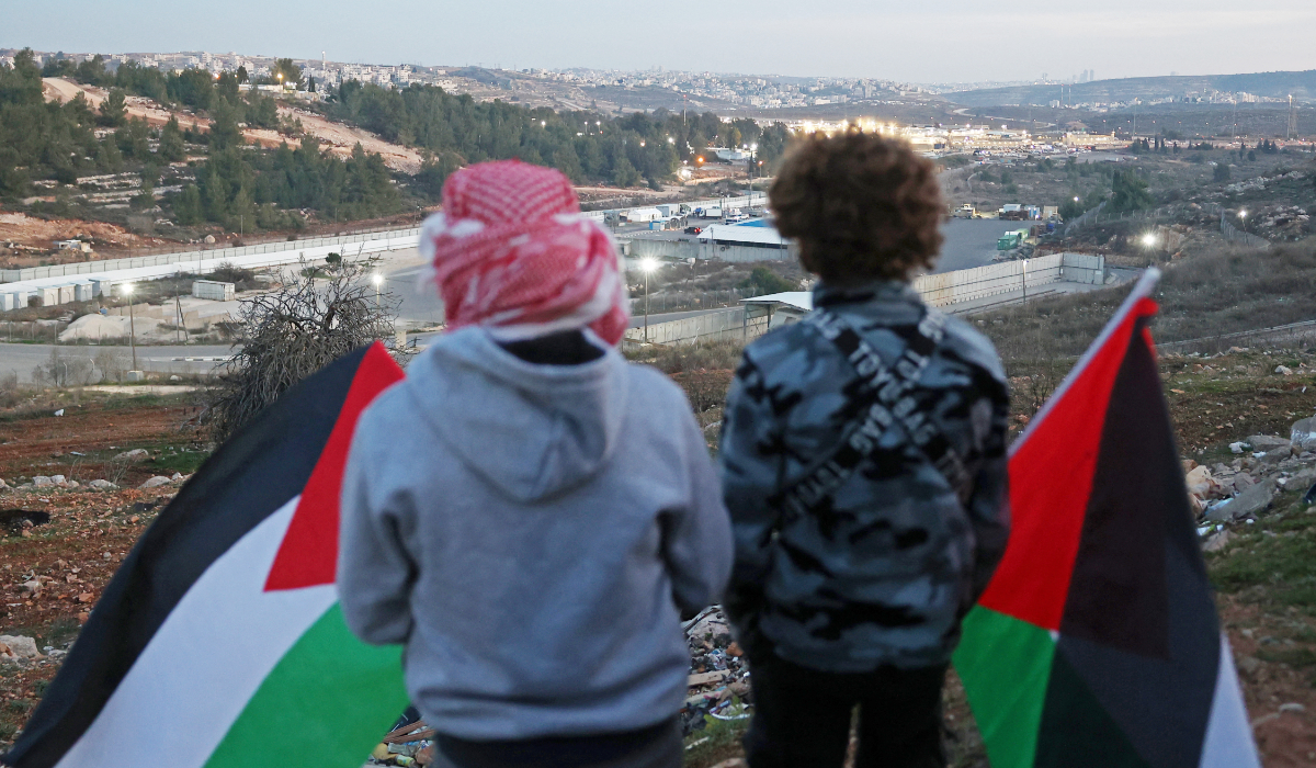 Family members and relatives of Palestinian prisoners, wait for their release against the backdrop of Ofer Prison, in the west of Ramallah on January 19, 2025. (AFP)