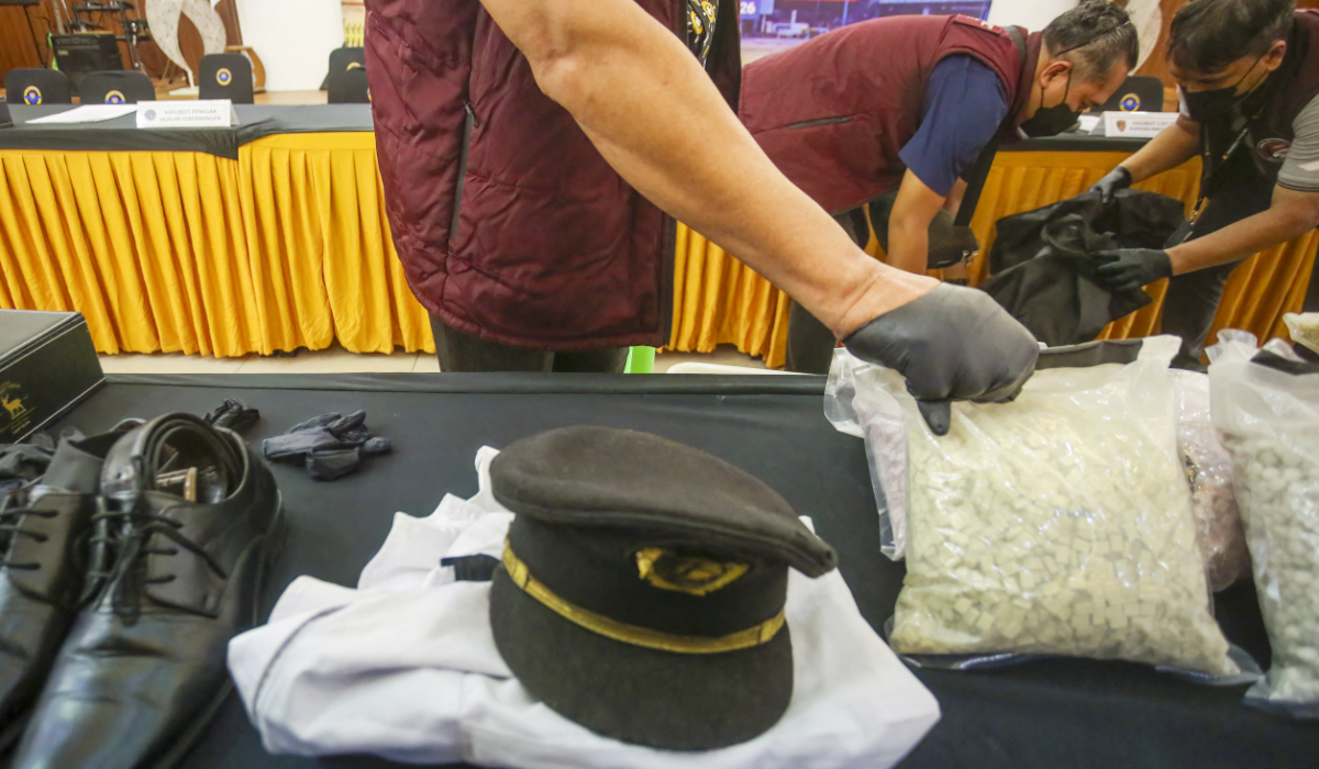 Indonesian Customs officials prepare to display the uniform of a Malaysian pilot and drugs he smuggled as evidence before a press conference at Soekarno-Hatta International Airport in Tangerang, near Jakarta, on July 31, 2026. (AFP)