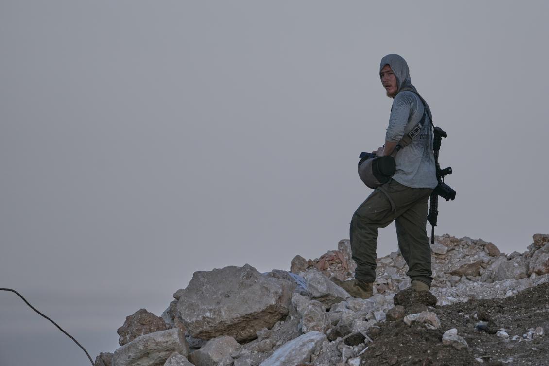 Above, an armed Israeli settler stands on a hillside overlooking the Palestinian town of Tell, in the occupied West Bank, on July 31, 2026. (AP)