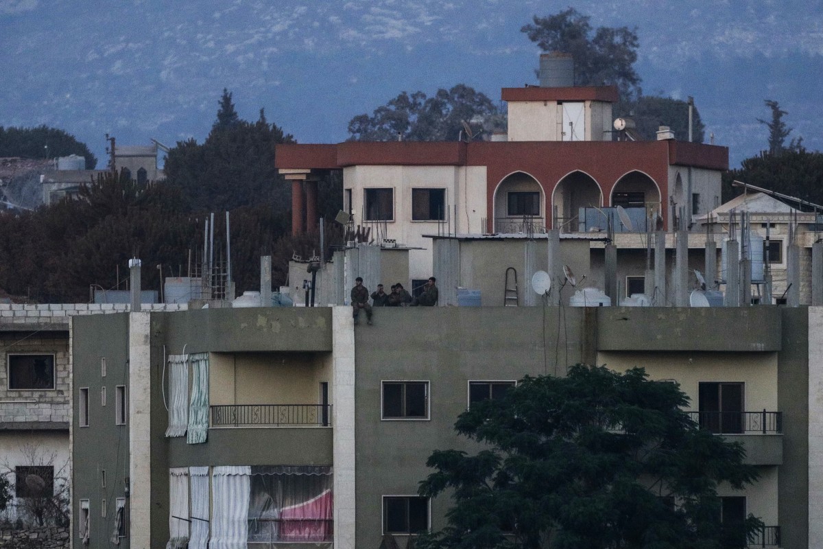 A photograph taken from the southern Lebanese village of Zawtar al-Gharbiyah shows Israeli soldiers standing on the roof of a residential building in nearby Zawtar Al-Charkiyah on Aug. 4, 2026. (AFP)