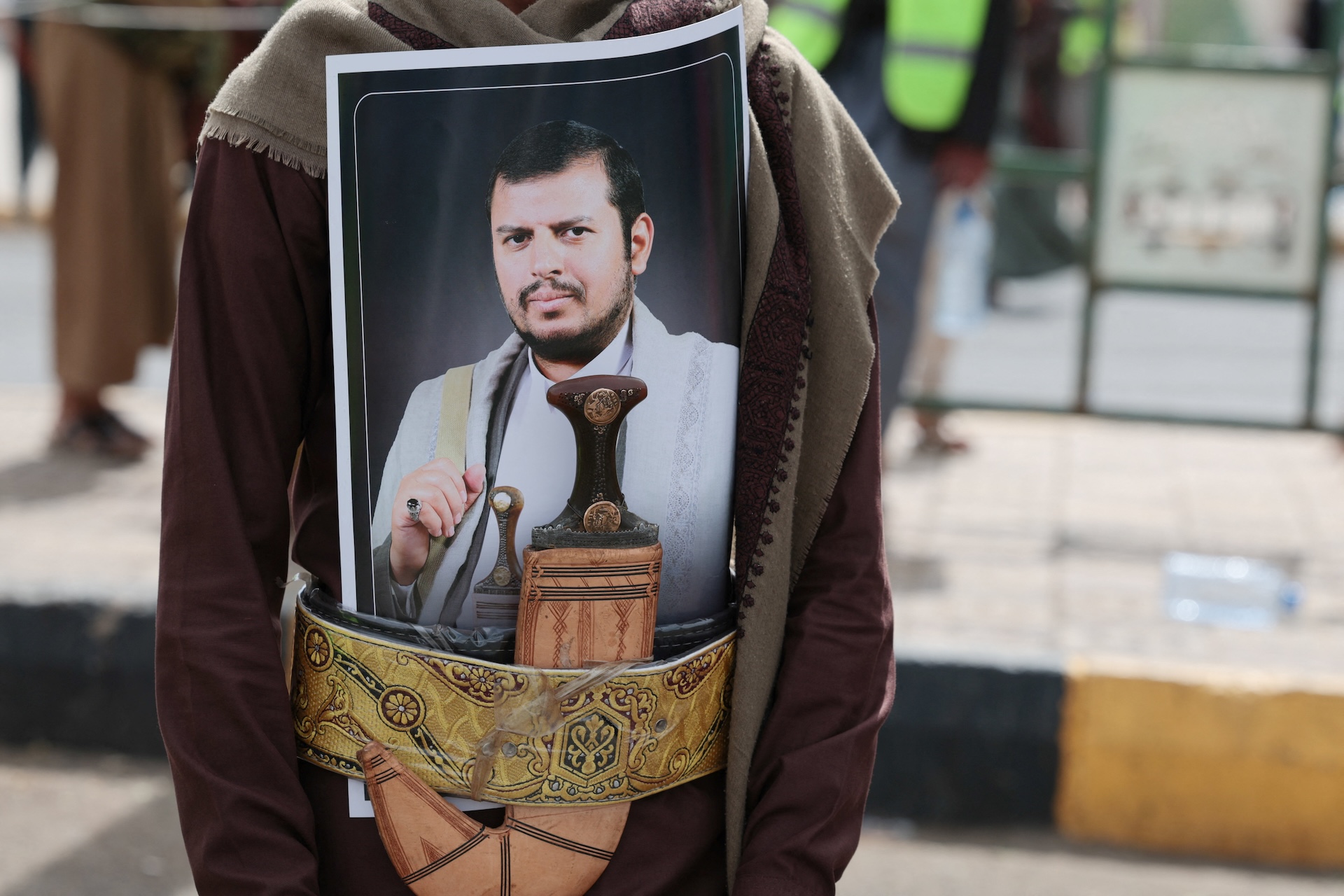 A Houthi supporter sports a poster of the group's leader, Abdul-Malik al-Houthi, in his dagger's belt, during a rally against the Saudi-led coalition's restrictions on Houthi-controlled areas, which the group describes as a blockade, in Sanaa, Yemen, July 17, 2026. (REUTERS)