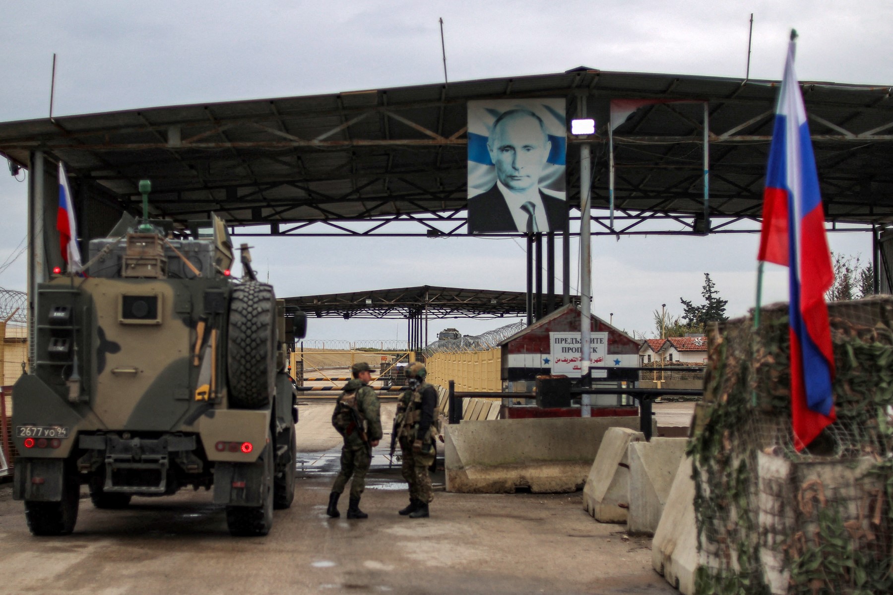 A portrait of Russian President Vladimir Putin hangs as military trucks enter Russia’s leased Hmeimim base in Syria’s Latakia province on Dec. 29, 2024. (AFP)
