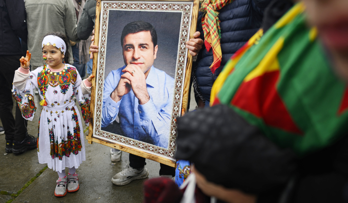 A Kurdish child stands next to a portrait of Selahattin Demirtas, jailed ex co-leader of pro-Kurdish Peoples' Democratic Party (HDP), during a Kurdish celebration of the Nowruz in Istanbul on March 22, 2026. (AFP)