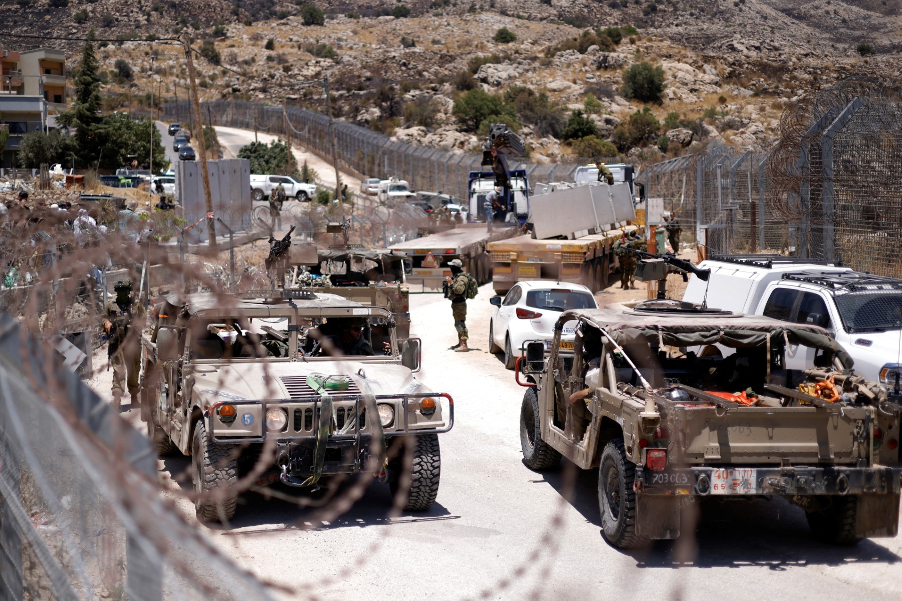 Israel military vehicles drive along the border fence into Israel, near the town of Majdal Shams, in the occupied Golan Heights, on July 17, 2025. (AFP)