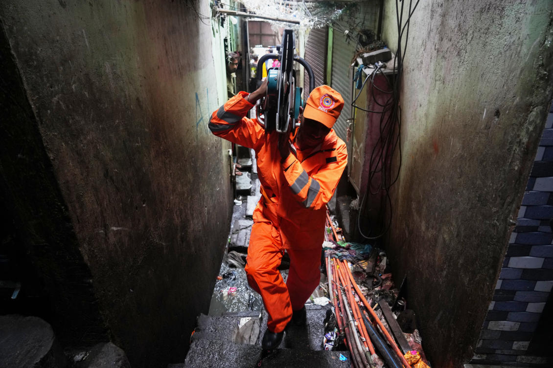 Above, a rescue worker carries equipment to an area affected by a landslide in Mumbai, India on Aug. 12, 2026. (AP)